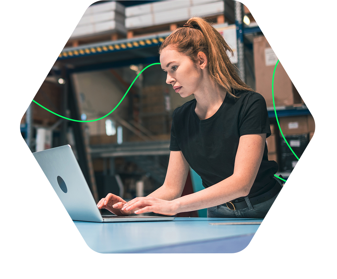 Woman using laptop in warehouse